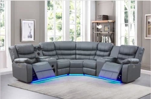 Gray sectional recliner sofa with blue LED lighting in a modern living room with large windows