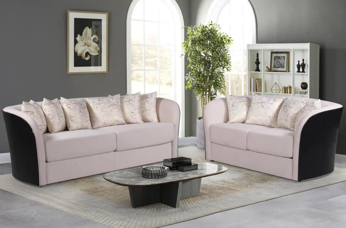 Modern living room with two-tone beige and black sectional sofas, glass coffee table, large arched windows, and gray walls with decor.