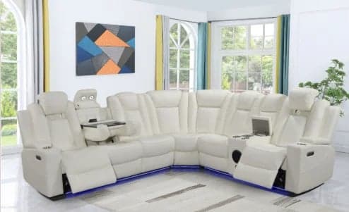 Modern cream-colored L-shaped sectional sofa with recliners and blue accent trim in a bright living room with windows