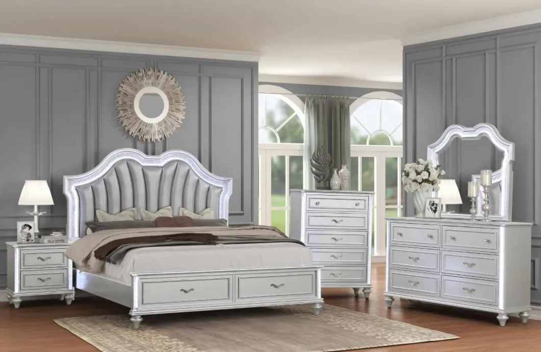 Silver Evangeline 4-piece bedroom set with a fan-tufted upholstered headboard, storage bed, dresser, chest, and nightstand below a sunburst mirror